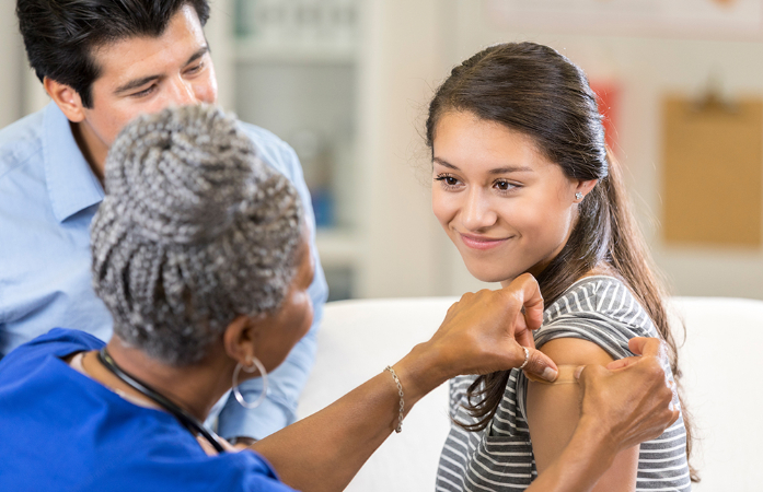  Woman placing bandage on girl's arm